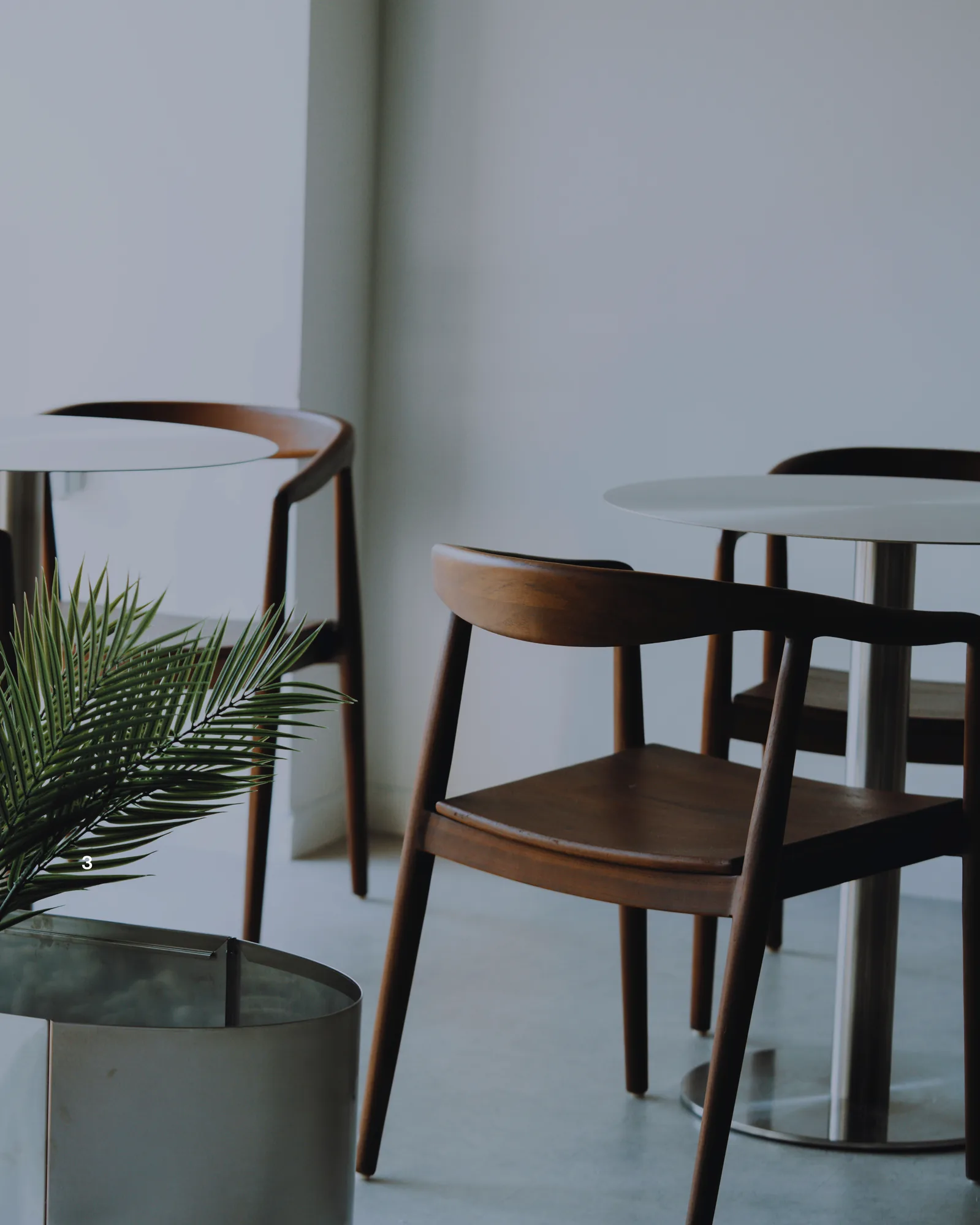 Wooden chairs and tables in the calm lounge area of ONE PULS Brussels