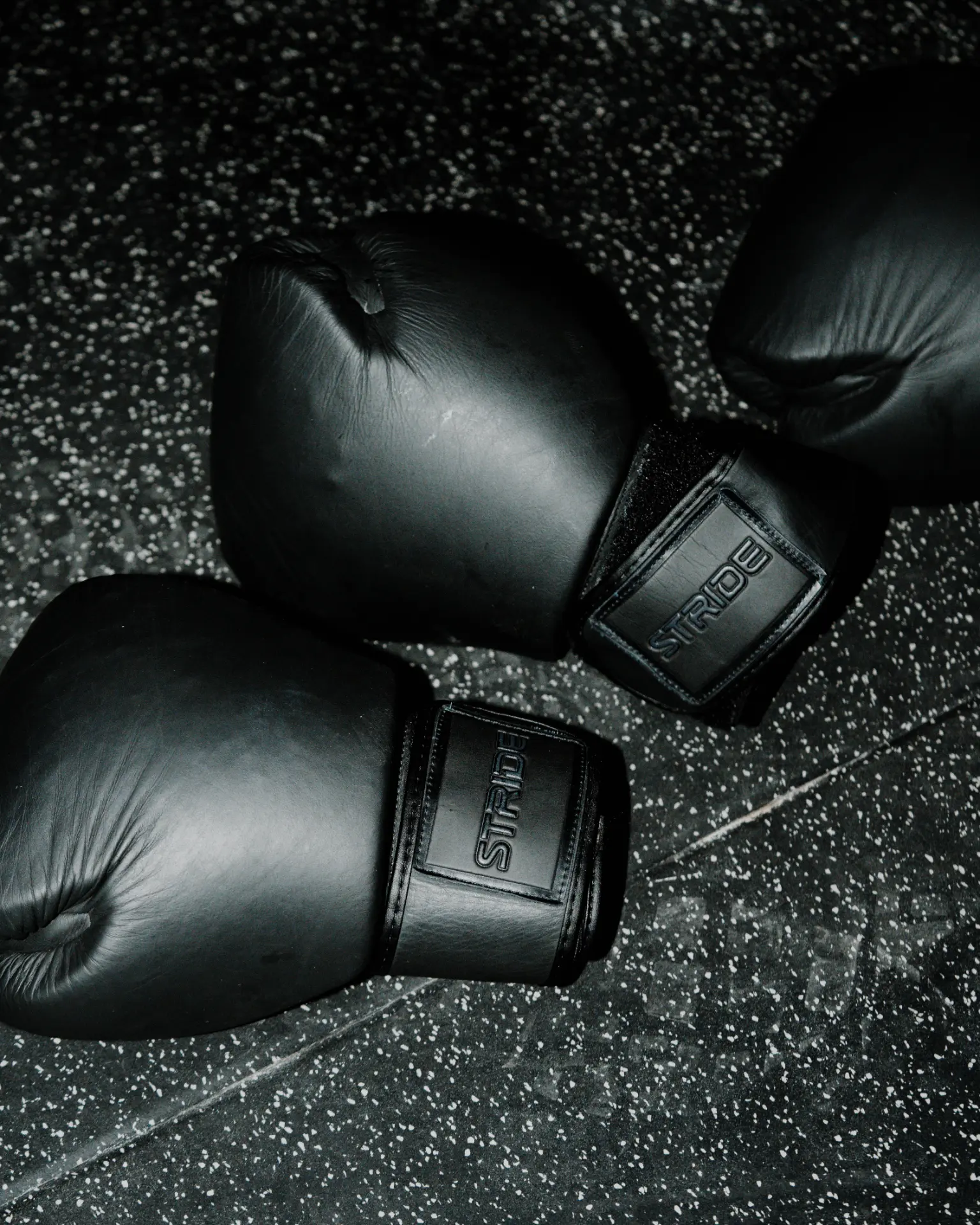 Boxing gloves lined up on the floor of the ONE PULS Boost room, Brussels