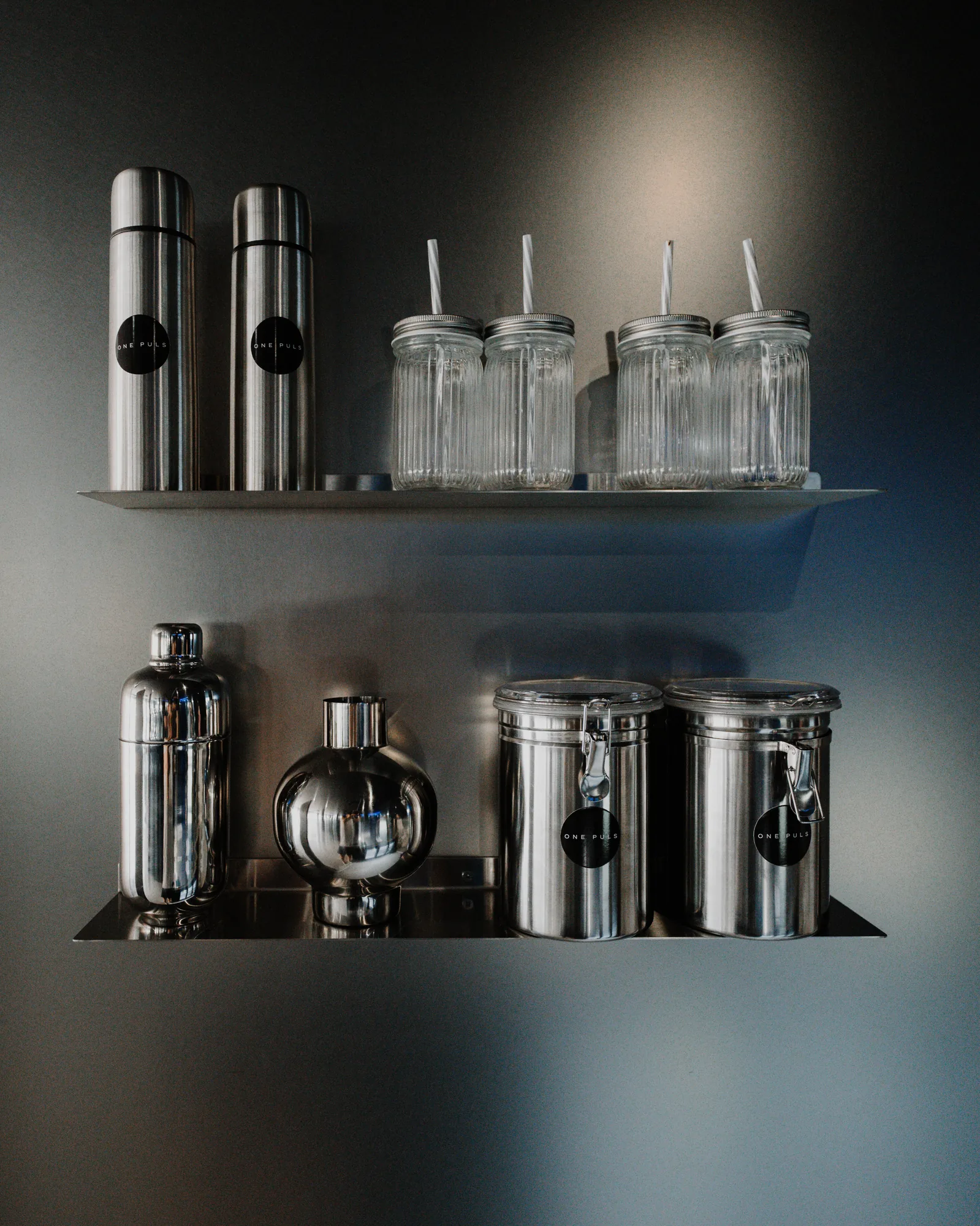 ONE PULS branded flasks, jars and shakers on the club bar shelves in Brussels