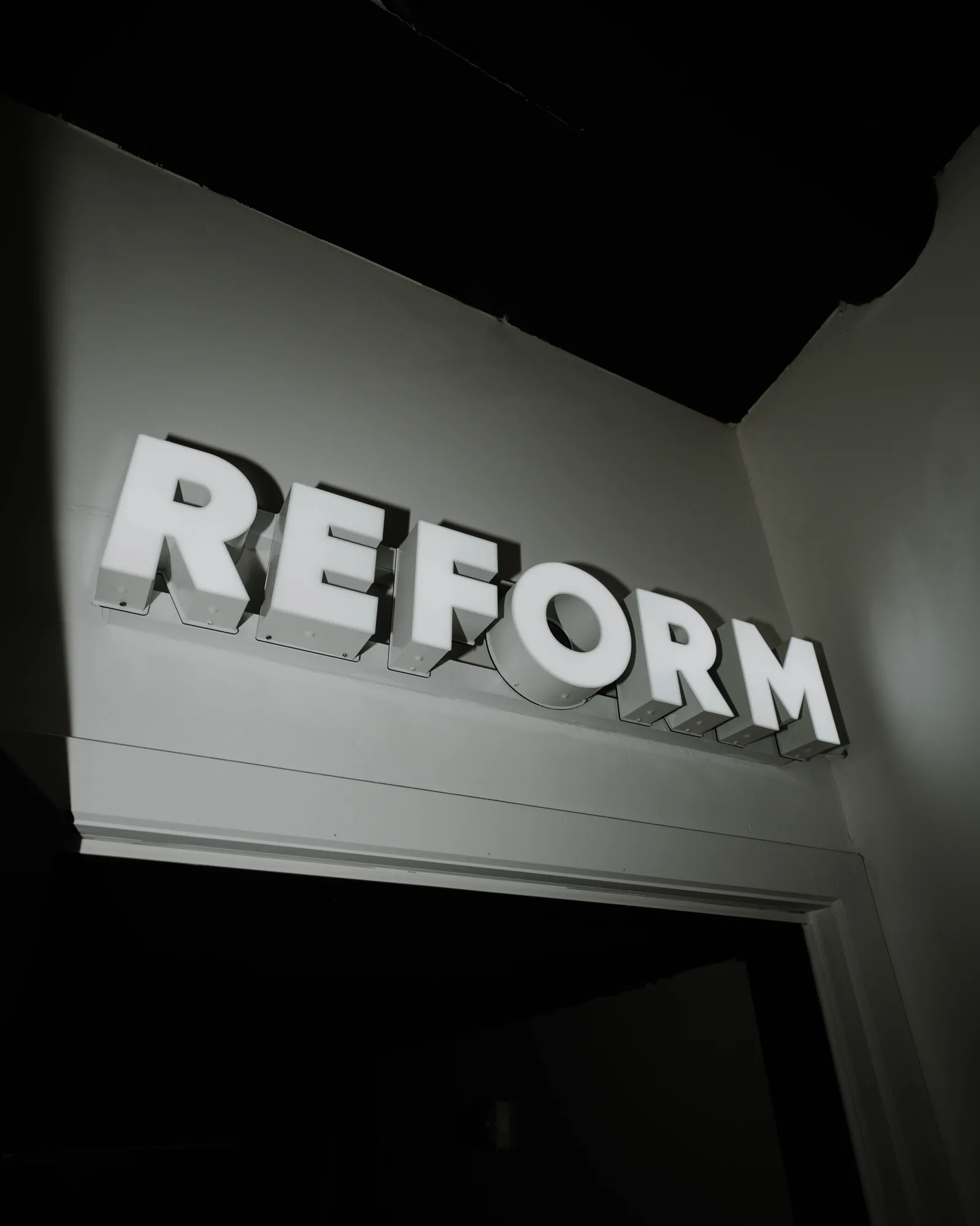 Illuminated REFORM sign at the entrance of the ONE PULS studio, Brussels
