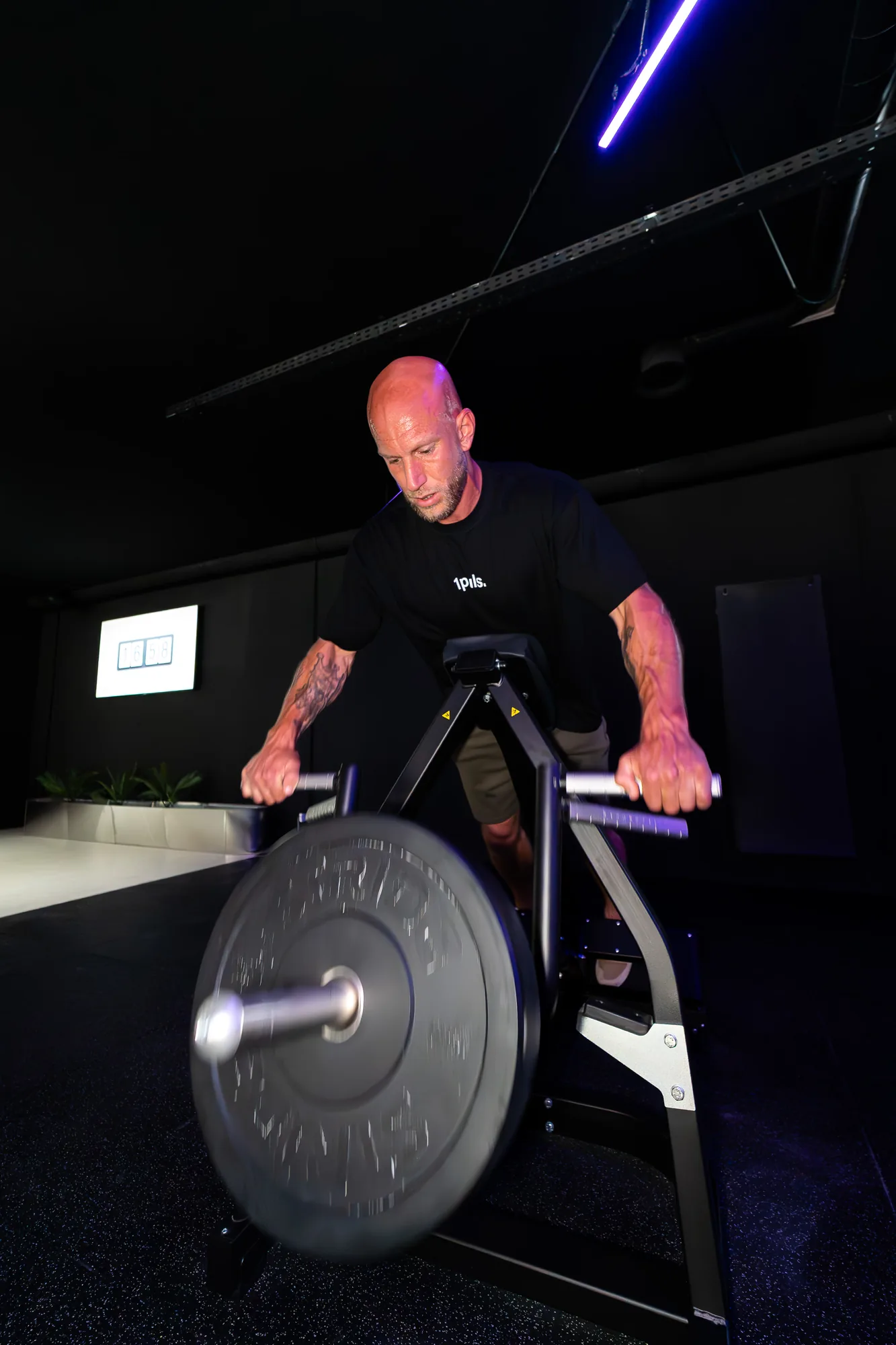 Coach training on a Rogue Echo bike in the ONE PULS open gym, Brussels