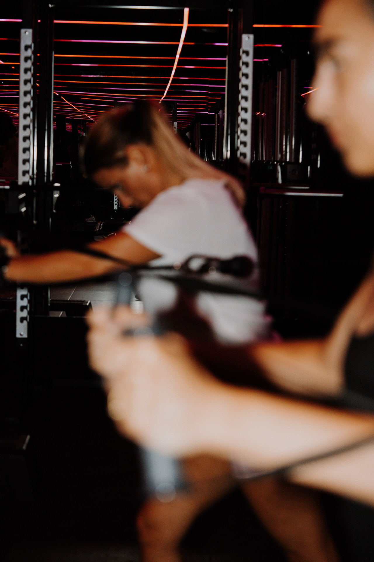 Neon reflections and movement during a class in the ONE PULS Boost room, Brussels