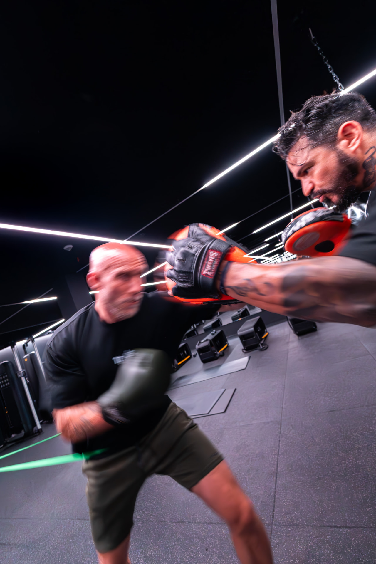Group cardio boxing class hitting the punch bag at the ONE PULS Boost room, Brussels (different angle)